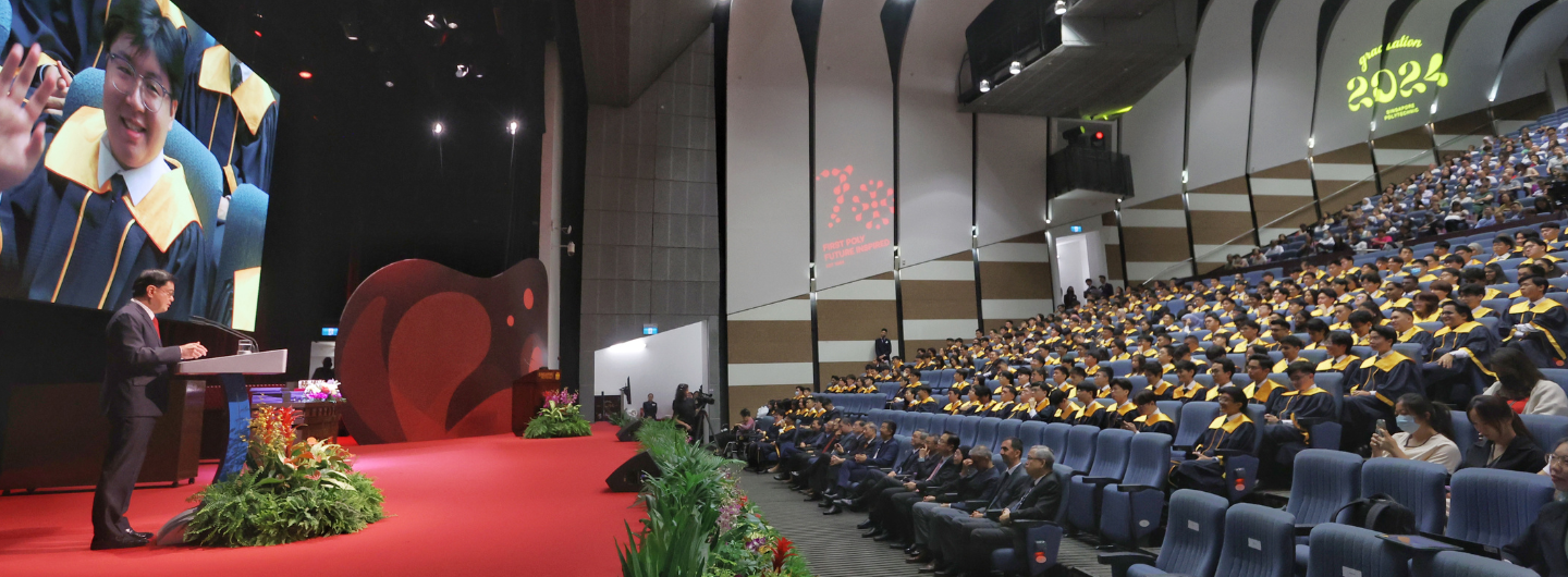 Auditorium view of speaker, audience in graduation robes, '2024 Singapore Polytechnic' on wall.